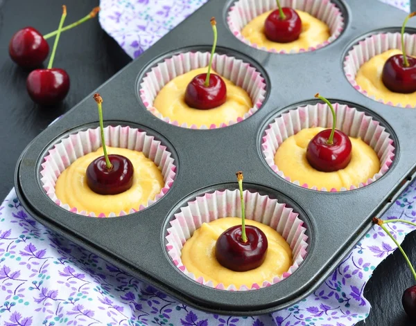 A tray of raw muffins with cherry. Ready for insertion into the oven. — 图库照片