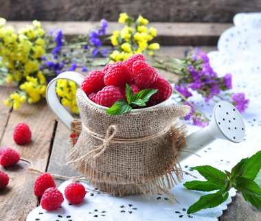 Organik ahududu ahşap arka plan üzerinde bir Bahçe Sulama olabilir