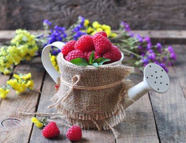 Organik ahududu ahşap arka plan üzerinde bir Bahçe Sulama olabilir