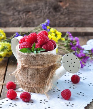 Organik ahududu ahşap arka plan üzerinde bir Bahçe Sulama olabilir