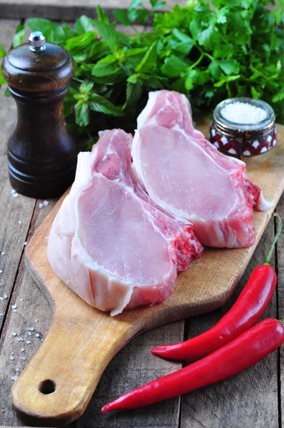 raw pork chop on the bone with parsley, mint, pepper and sea salt