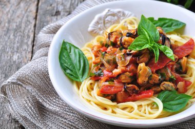 pasta with mussels, pepperoni, bacon, tomato and basil