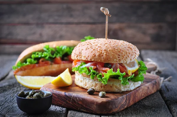 Hamburguesa con salmón en escabeche, lechuga, cebolla blanca y alcaparras —  Fotos de Stock