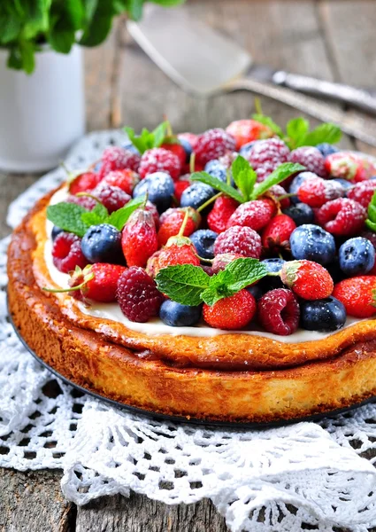 Cottage cheese casserole with fresh strawberries, blueberries, raspberries and mint and powdered sugar — Stock Photo, Image