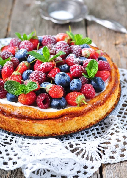 Cottage cheese casserole with fresh strawberries, blueberries, raspberries and mint and powdered sugar — Stock Photo, Image