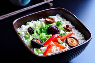ramen noodles with shiitake mushrooms, green peas, sweet pepper and coriander