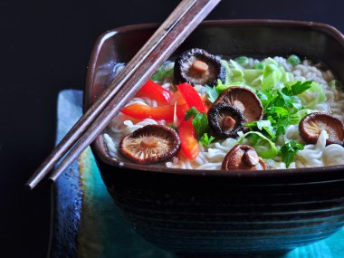 ramen noodles with shiitake mushrooms, green peas, sweet pepper and coriander