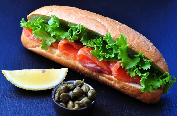 Sandwich with pickled salmon, lettuce, white onion and capers — Stock Photo, Image