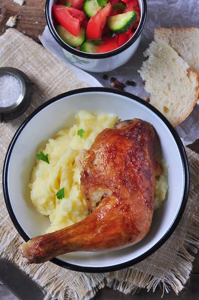 Baked chicken leg with mashed potatoes and vegetable salad on a wooden table. selective focus. rustic style. — 스톡 사진