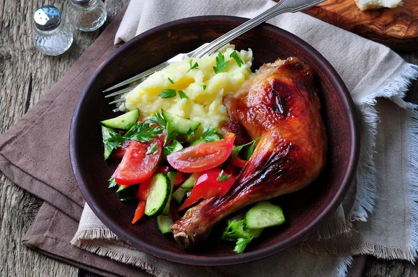 Glazed roasted chicken leg with mashed potatoes and vegetable salad on a wooden background — 스톡 사진