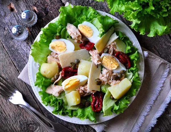 Salata marul, domates, patates, Kapari ve zeytinyağı ile giyinmiş parmesan peyniri, haşlanmış ile konserve ton balığı, göbek salatayı kurutulmuş. Seçici odak. rustik tarzı.