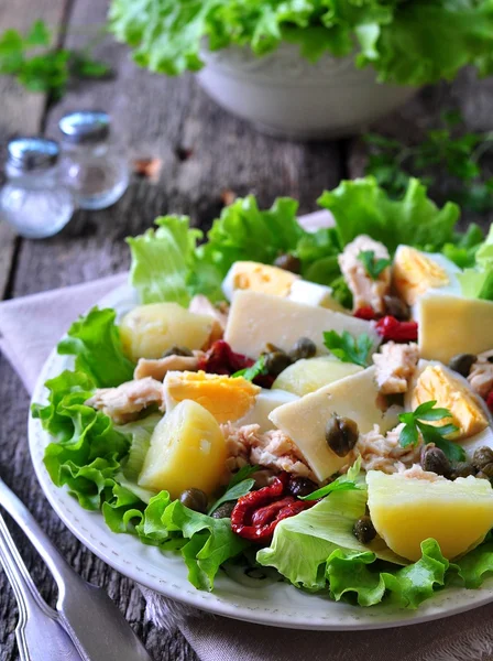 Salata marul, domates, patates, Kapari ve zeytinyağı ile giyinmiş parmesan peyniri, haşlanmış ile konserve ton balığı, göbek salatayı kurutulmuş. Seçici odak. rustik tarzı.