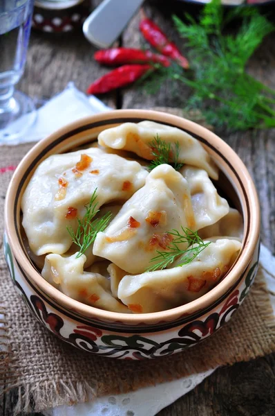 Dumplings with potatoes and mushrooms with fried onions in a traditional ceramic plate on a wooden table. Ukrainian traditional cuisine. rustic style. selective focus — Φωτογραφία Αρχείου