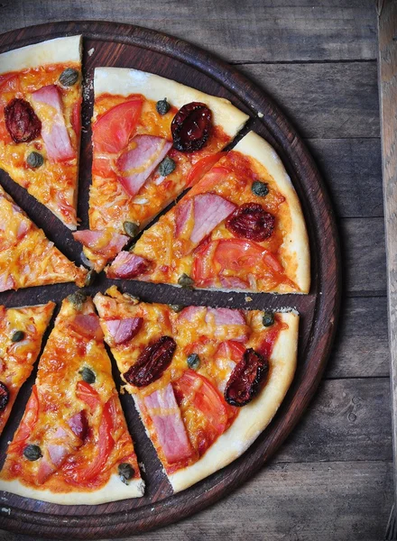 Homemade pizza with smoked meat, dried and fresh tomatoes, capers, onions and tomato sauce — Stock Image Homemade pizza with smoked meat, dried and fresh tomatoes, capers, onions and tomato sauce Royalty Free Stock Photos