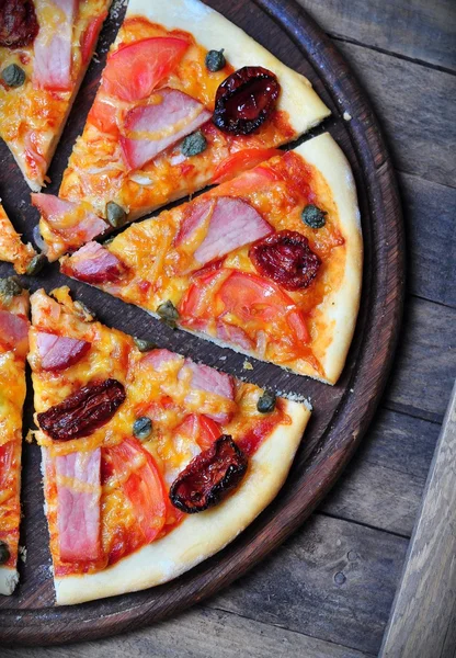 Homemade pizza with smoked meat, dried and fresh tomatoes, capers, onions and tomato sauce — Stock Image Homemade pizza with smoked meat, dried and fresh tomatoes, capers, onions and tomato sauce Royalty Free Stock Photos