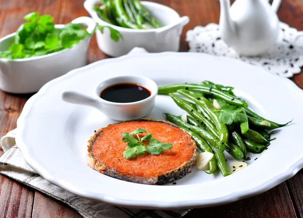 Salmon steak with green beans, garlic, black sesame and soy sauce. Selective focus.