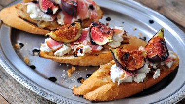 karamelize soğan, keçi peyniri, jamon ve ızgara incir tost. seçici odak