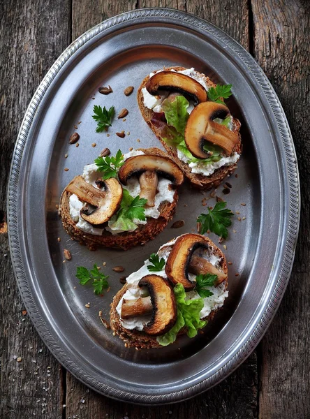 Sandwich mit Ziegenkäse, gebratenen Pilzen und Salat auf einem Eisenblech. rustikaler Stil — Stockfoto