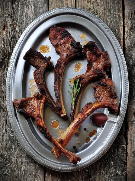 Gebratenes Lamm mit Rosmarin und Knoblauch auf einem eisernen Teller — Stockfoto