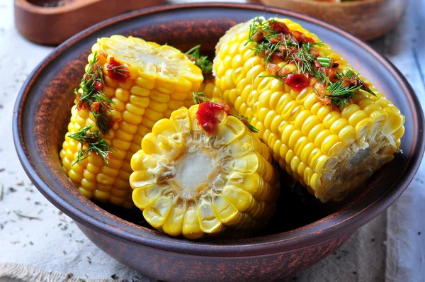 Boiled corn with hot tomato sauce, herbs, salt and spices — Stock Photo, Image