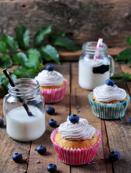 Blueberry homemade cupcakes with a jar of milk on a wooden background, rustic style — Stock Fotó