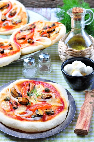 Mini pizza caseira com mexilhões, lula, cebola, tomate, mussarela e alcaparras — Fotografia de Stock