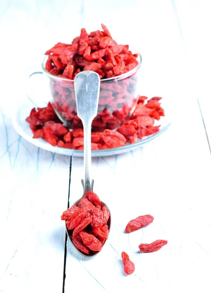 Dried goji berries on a blue and white wooden background — Stock Fotó