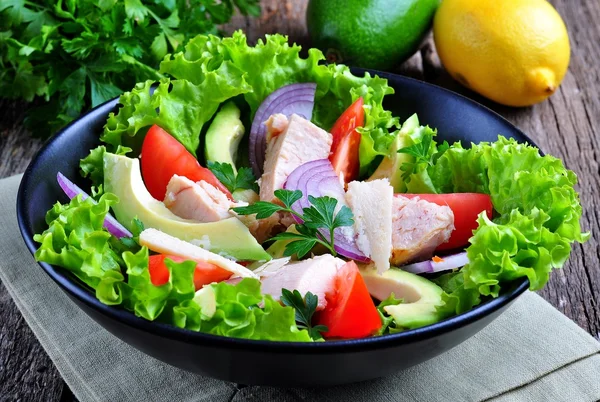 Healthy salad of avocado, tomatoes, canned tuna, onions and lettuce with parmesan, parsley and olive oil — Stock Photo, Image