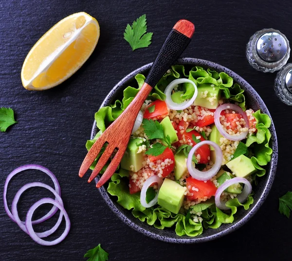 Vegetarische couscous salade, avocado, tomaten, rode ui met olijfolie en peterselie. — Stockfoto