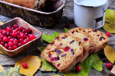Ev yapımı kek ile taze ve kurutulmuş cranberries üzerinde sonbahar yaprakları