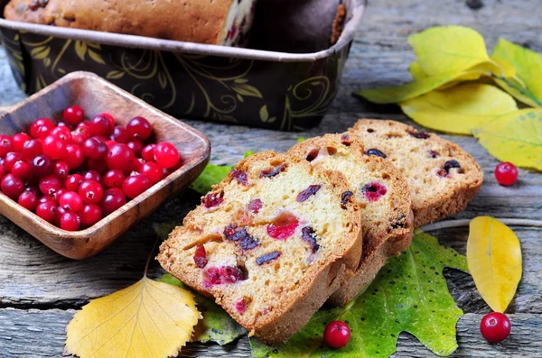 Ev yapımı kek ile taze ve kurutulmuş cranberries üzerinde sonbahar yaprakları