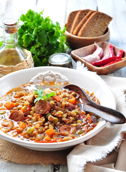 Lentil soup with chicken and pepperoni sausage, onion, carrot, sweet pepper, garlic and parsley. — Stock fotografie