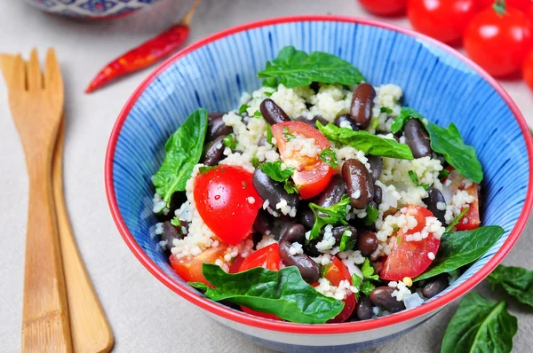 Ensalada de cuscús y judías marrones, con aceite de oliva, con tomates cherry ecológicos, cebolla, perejil y espinacas — Foto de Stock