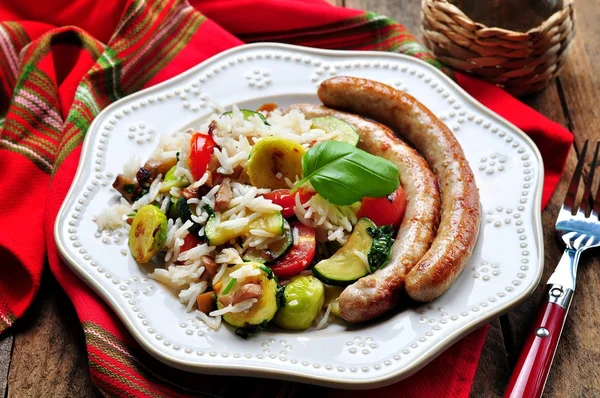 Fried rice with Brussels sprouts, mushrooms, zucchini, garlic, cherry tomatoes, basil, parsley and chicken sausages — Stock Photo, Image