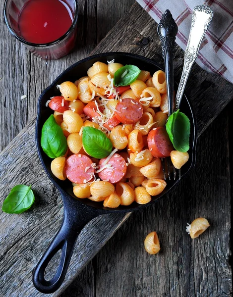 Паста с сосисками в томатном соусе с базиликом и сыром — стоковое фото