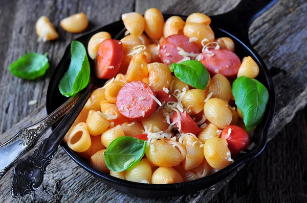 Macarrão com salsichas em molho de tomate com manjericão e queijo — Fotografia de Stock