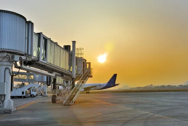 Aerobridge parked in the airport at sunset — Stock Photo, Image