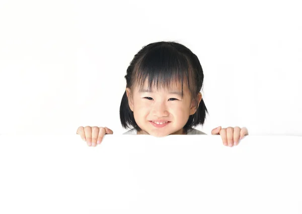 Asian little girl hiding behind white board — Stock Photo, Image