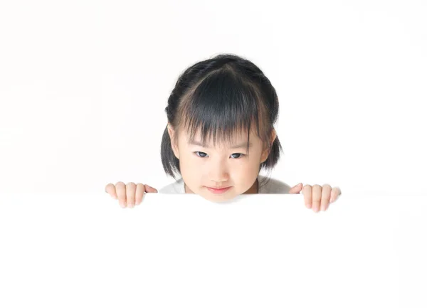 Asiático menina escondendo atrás branco bordo — Fotografia de Stock