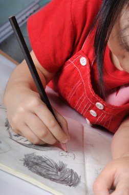 3 yıl yaşlı Asyalı kız çizer ve sketchs p ile birçok insan yüzlerini