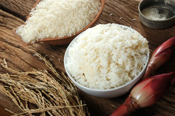 Arroz cocido, arroz sin cocer y arroz con cáscara sobre tabla de madera —  Fotos de Stock