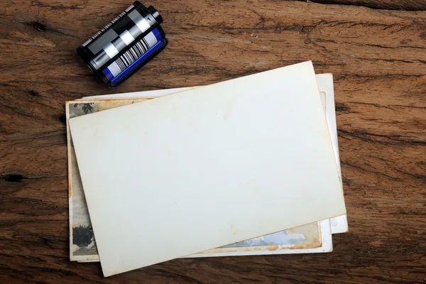 Old paper photo frame with camera film on wood background — Stock Photo, Image