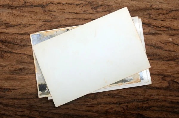 Old paper photo frame on wood background — Stock Photo, Image