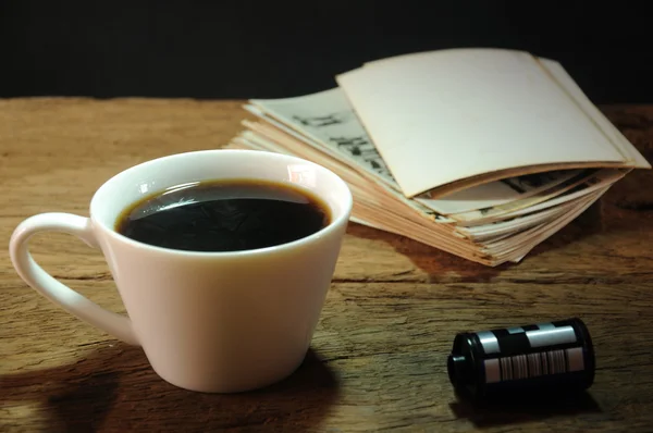 Tasse Kaffee und alter Fotorahmen aus Papier auf Holz — Stockfoto