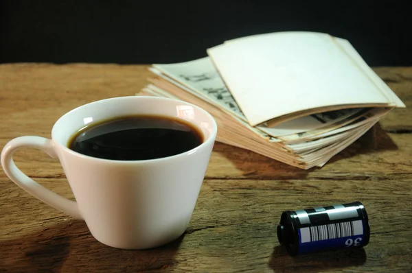 Kopp kaffe och gamla papper fotoram på trä bakgrund — Stockfoto