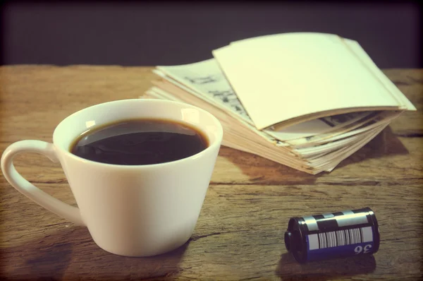 Kopje koffie en oud papier fotolijstjes op hout achtergrond — Stockfoto