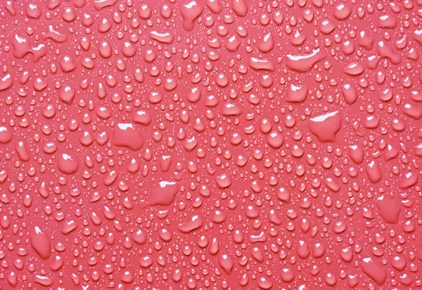 Gocce d'acqua su sfondo rosso — Foto Stock