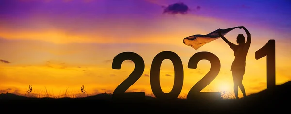 Silhouette of Woman to welcome the new year 2021 with Sunset background. Copy space and Panoramic horizontal design.