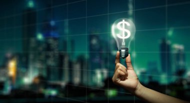 El 'in içinde dolar işareti ve Night City arkaplanı olan parlayan ampulü tutarken çift pozlama. Para üretme fikri ve dolar kurunun büyümesi kavramı.