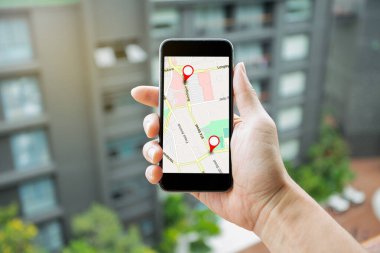 Hedef ağ bağlantısına giden GPS haritalı akıllı telefonu tutan adam. Konum Sokak Haritası GPS Simgeleri Navigasyon ve Kırmızı konum simgesi. Çevrimiçi Navigasyon Konsepti.